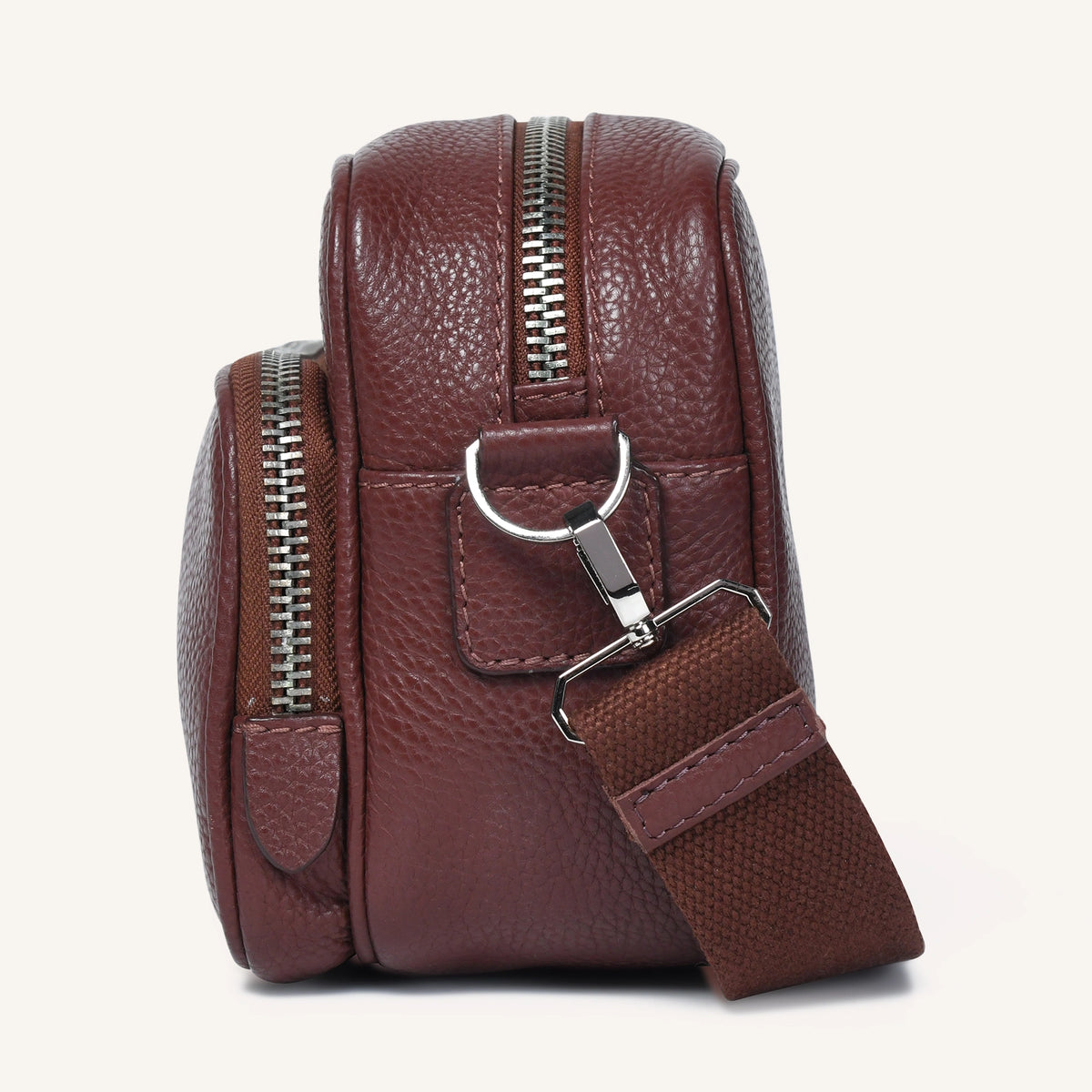 Brown leather crossbody bag with a strap on a white background