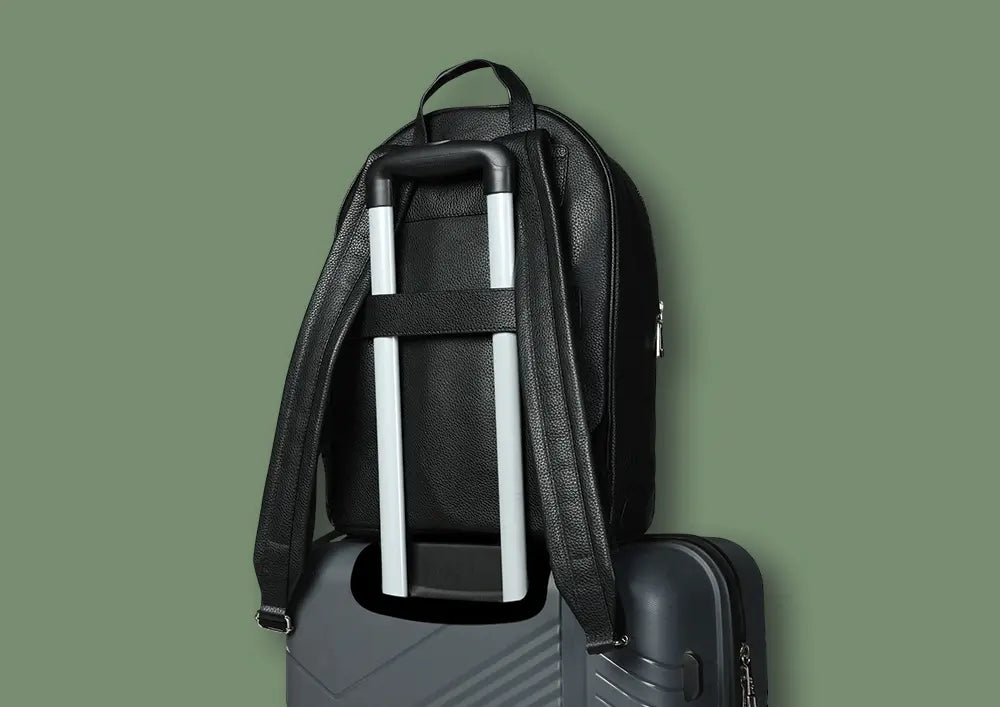 commute pack backpack - black leather backpack secured on top of a suitcase with trolley handle