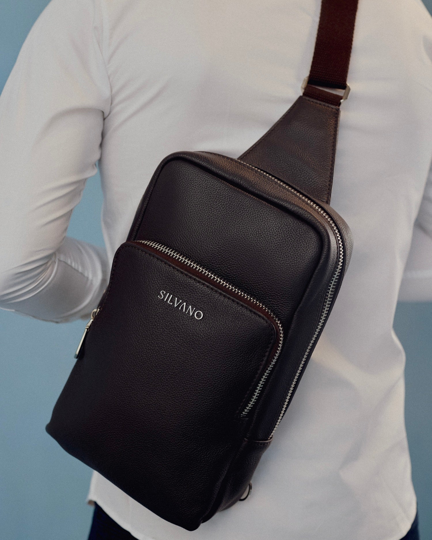 silvano jet bag crossbody bag - close-up of black leather crossbody bag worn over shoulder with white shirt