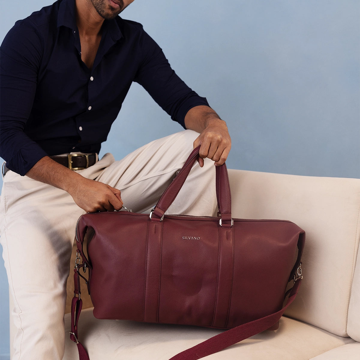MAN HOLDING KNAPSACK WEEKENDER DUFFLE BAG - OX BLOOD