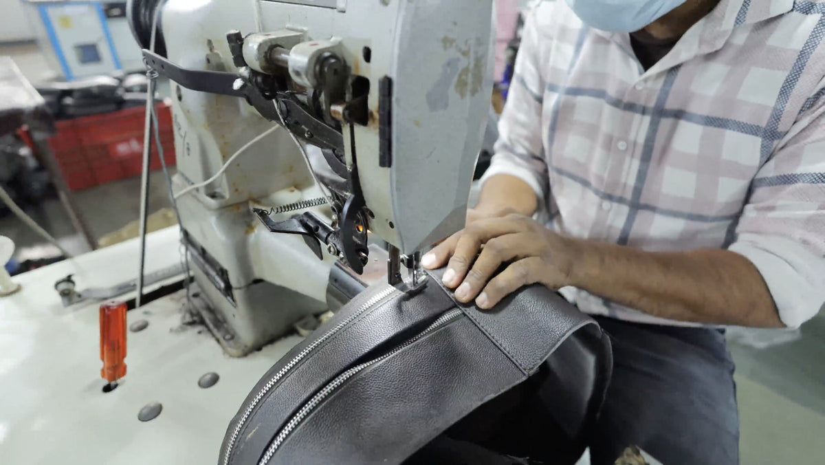 A Silvano craftsman stitching a leather bag in our workshop